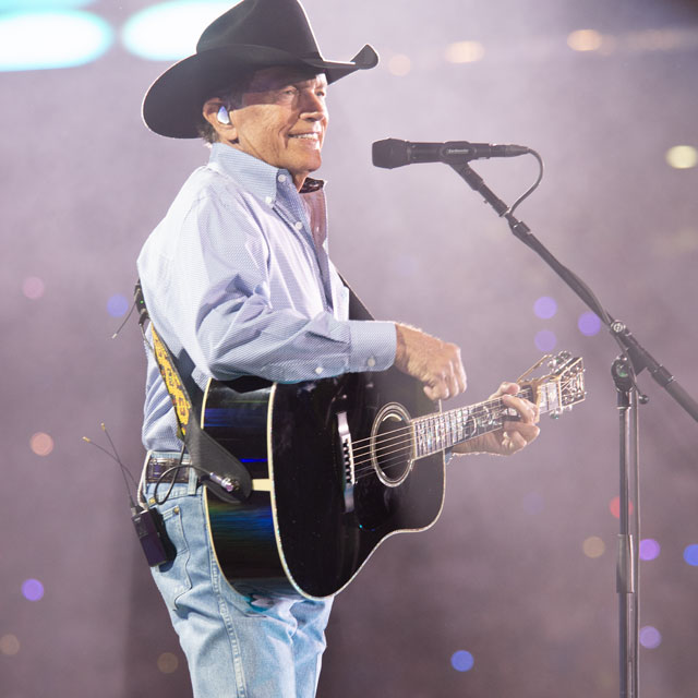 George Strait playing a guitar on stage